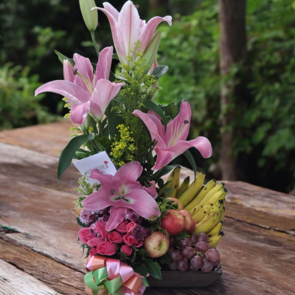 Arreglo de lirios rosas y frutas